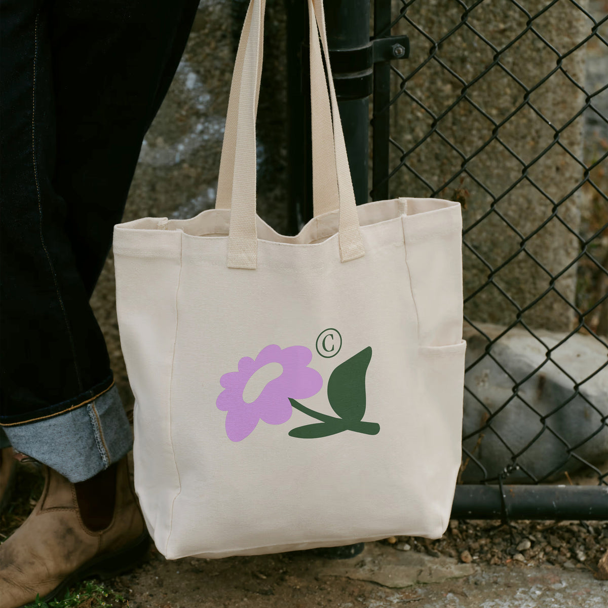 Tote bag Baby Flowers porté à la main, illustré d'une grande fleur violette – sac maternité