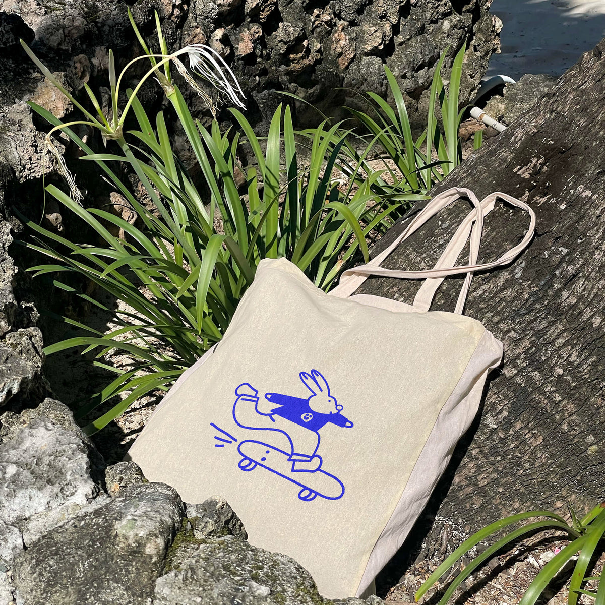Tote bag Sunday Club posé au milieu des plantes – sac pour jeunes parents