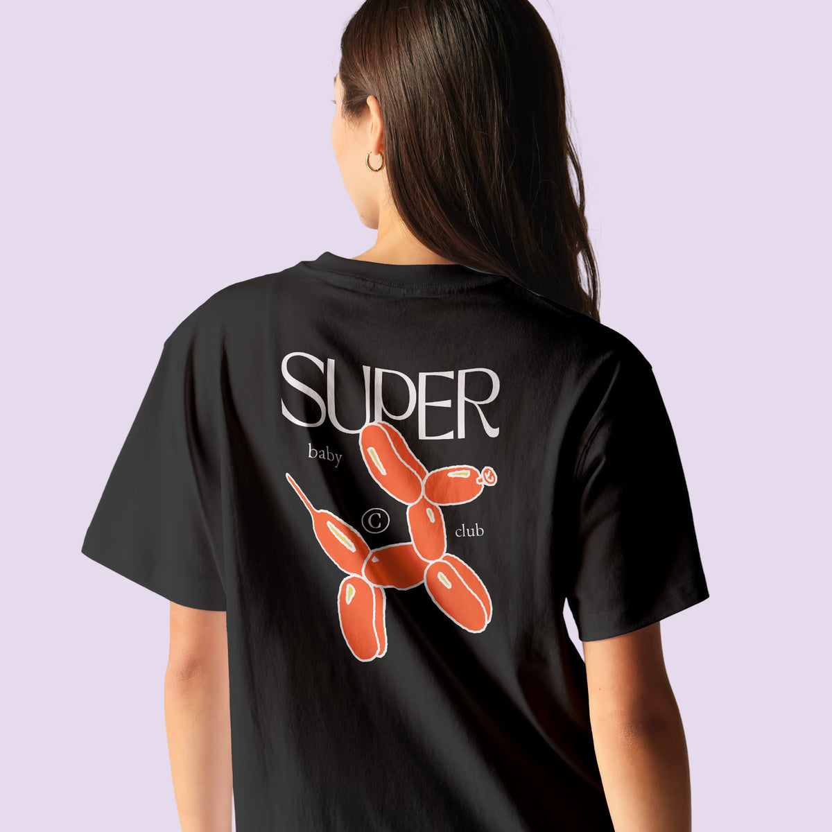 Femme de dos portant le t-shirt noir Super Baby Club au chien ballon orange – annonce grossesse