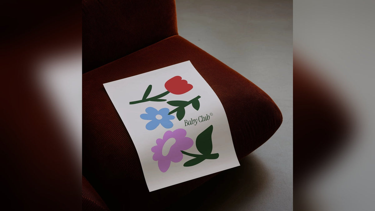 Affiche Baby Club Bouquet illustrée de fleurs posée sur un fauteuil, déco chambre bébé