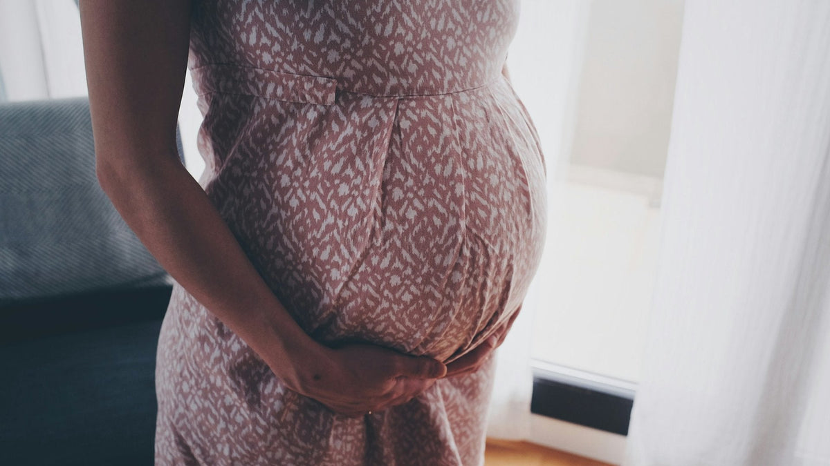 Femme enceinte qui tient son ventre chez elle
