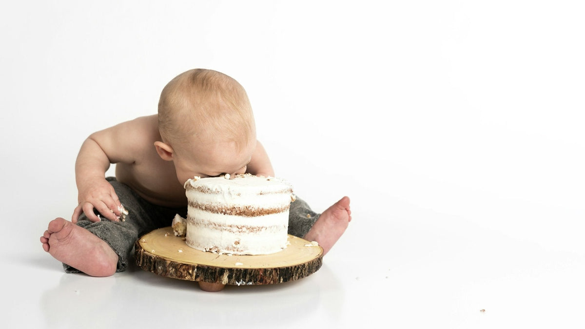 Bébé qui plonge dans son gâteau de premier anniversaire