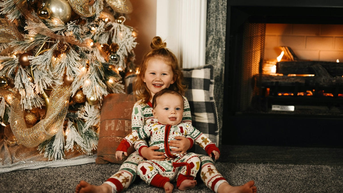 Deux enfants en pyjama de Noël devant le sapin